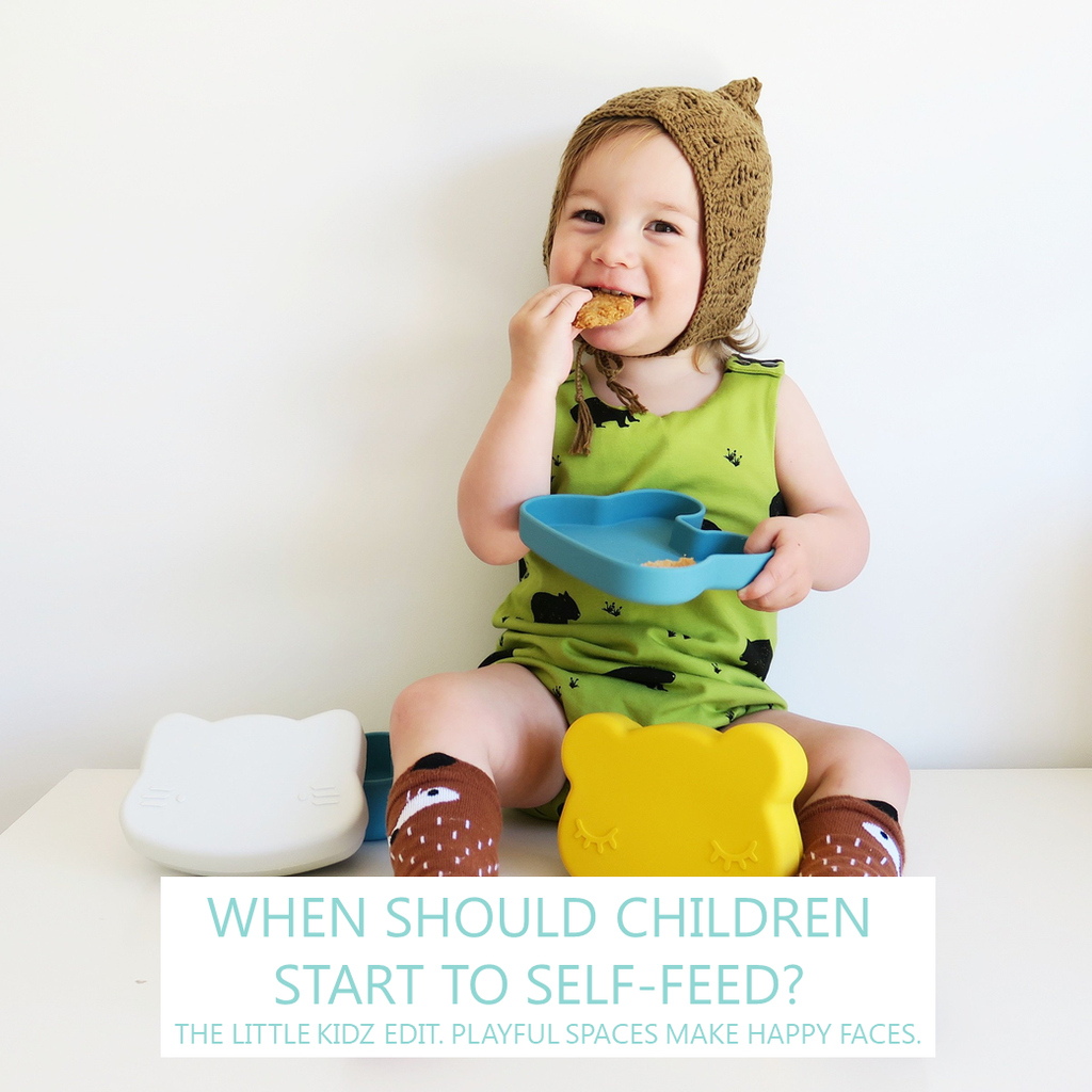 When should children start feeding themselves?